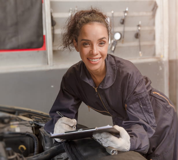 Young female mechanic works under the hood